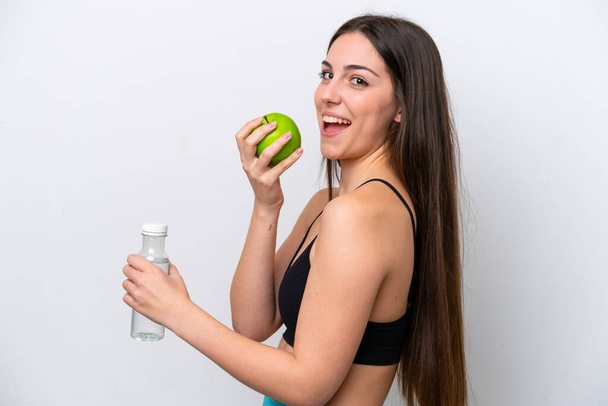 Young girl isolated on white background with an apple and with a bottle of water - Foto, immagini