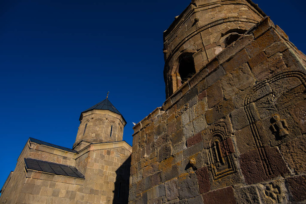 Kazbegi, Georgia : 10-11-2022 : close up of ancient Gergeti Trinity Church and glorious Caucasus mountains around - Fotografie, Obrázek