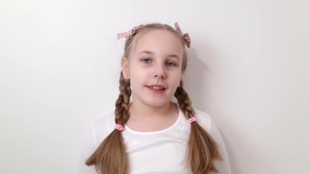 Portrait of happy smiling little child girl isolated on white background. Beauty, children`s fashion concepts - Felvétel, videó