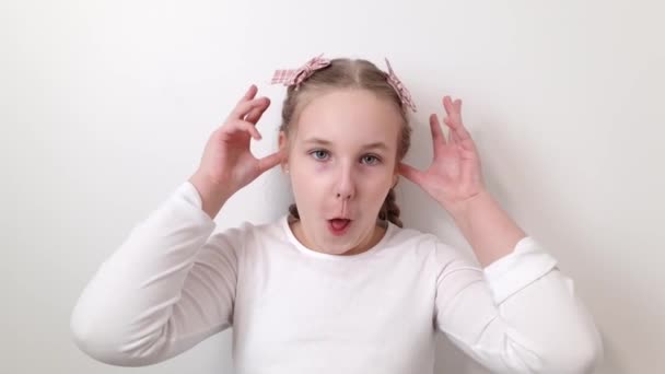 Happy joyful little girl making funny faces on white background. Childhood, happiness, lifestyle concepts - Felvétel, videó