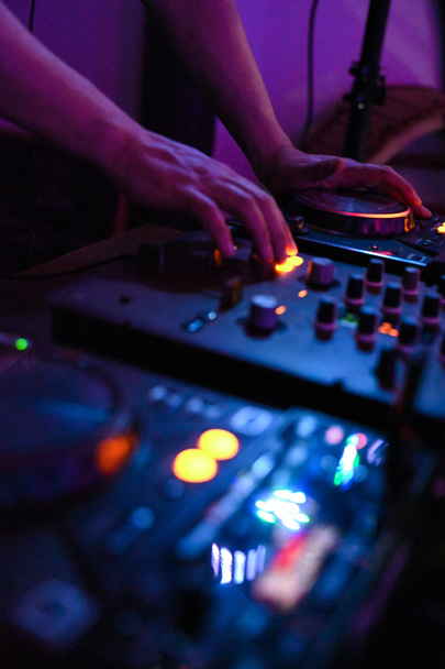 DJ in discoteca pronto a mixare la musica per voi. Colori brillanti e saturi in una notte fluorescente. - Foto, immagini