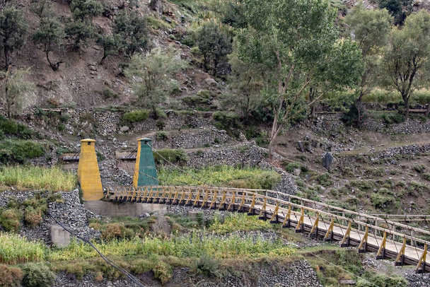Old wooden suspension bridge in Chitral Valley, Karakoram Highway, Pakistan - Fotografie, Obrázek