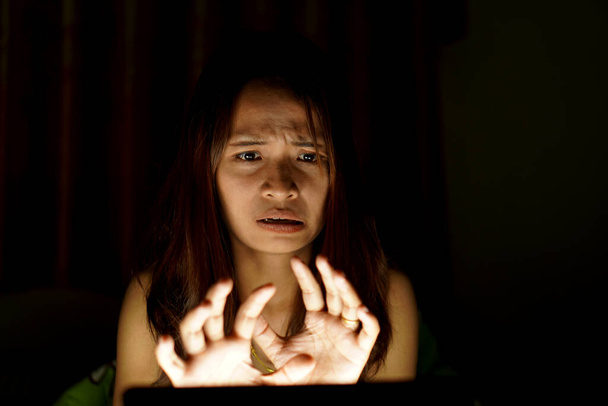Asian women suffer from eyestrain from looking at computers in low light. watch movies online - Foto, afbeelding