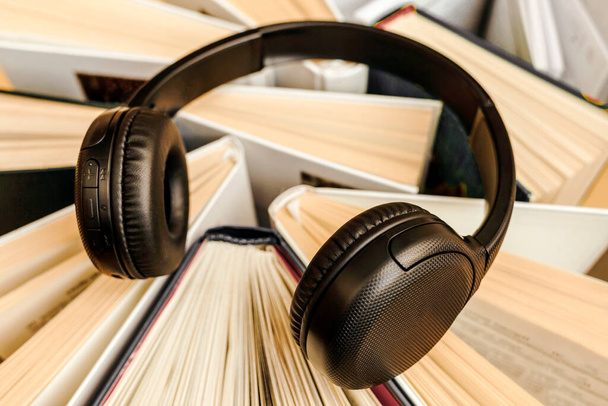 Audio Book concept with large heap of Books and Headphones. Online Studying, Learning or Self Study. Book Day. - Photo, Image