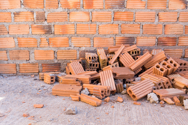 pile of bricks in construction site with brick wall background - Photo, Image