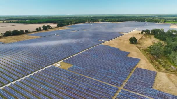 Luchtfoto van een grote duurzame elektriciteitscentrale met rijen fotovoltaïsche zonnepanelen voor de productie van schone elektrische energie. Concept van hernieuwbare elektriciteit zonder uitstoot. - Video