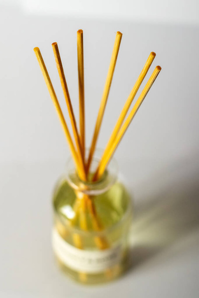 Un difusor de aroma con aceite aromático y palos en la habitación crea una atmósfera de paz y confort - Foto, Imagen