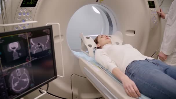 Tomografia 4K mózgu kobiety w klinice medycznej. Pacjentka robi tomografię komputerową prześwietlenia guza w jego głowie w pokoju tomografii komputerowej.. - Materiał filmowy, wideo