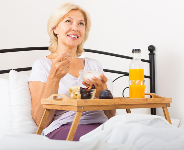 Mature woman enjoying healthy breakfast - Fotografie, Obrázek