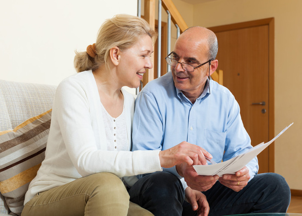 Mature couple with documents at home - Photo, Image