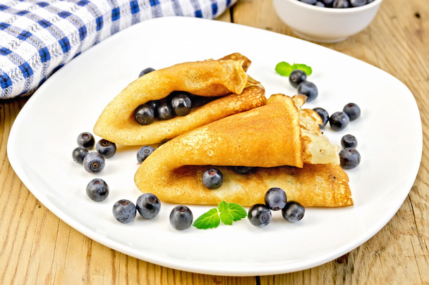 Pancakes with blueberries on wooden board - Фото, изображение