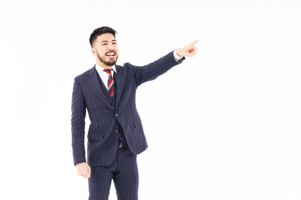 A man in a suit pointing up and white background - Foto, afbeelding