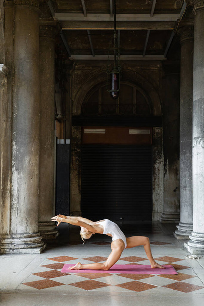 Convient aux sportives pratiquant le yoga sur tapis autour d'un bâtiment ancien avec des colonnes à Venise  - Photo, image
