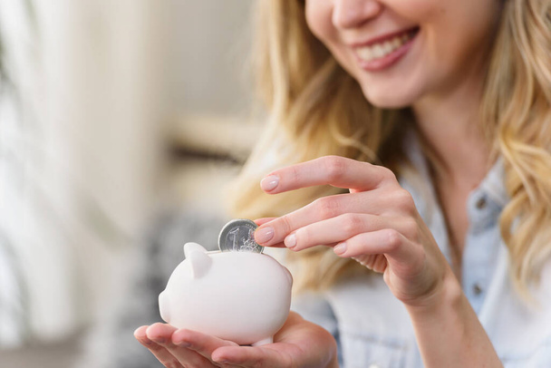 woman putting coin into piggy bank  - Photo, Image