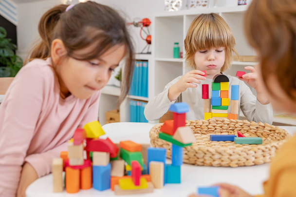 niños jugando con bloques de madera en el jardín de infantes - Foto, Imagen