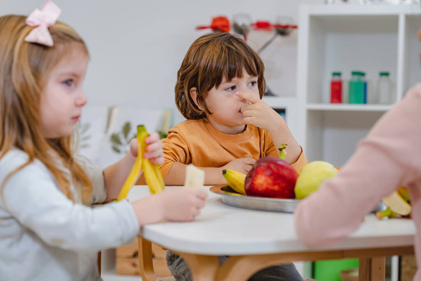 lapset syövät hedelmiä lounastauolla päiväkodissa - Valokuva, kuva