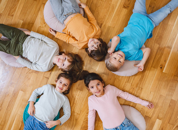 children lying on the floor in kindergarten - Zdjęcie, obraz