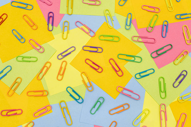 Multicolored paper clips on multicolored paper Sticky Notes, post it - Photo, image