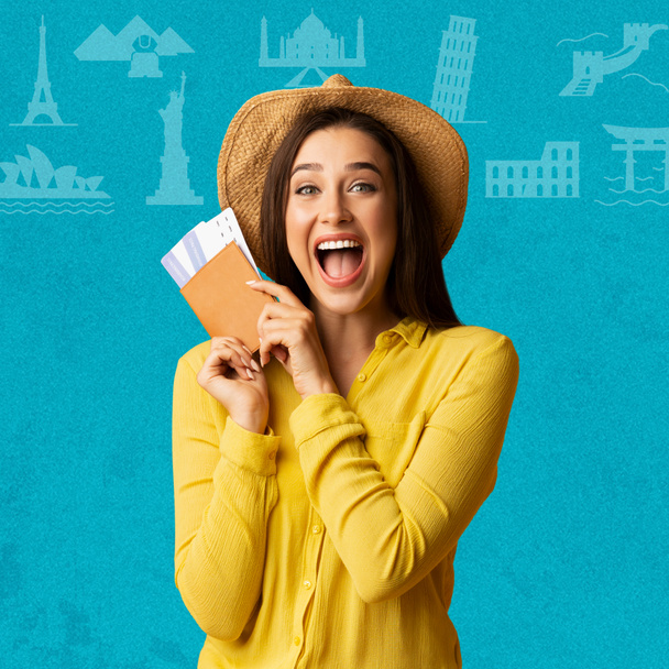 Glad excited young european woman tourist with open mouth holding tickets and passport for travel on blue background with abstract pictures, studio. Tourism, active lifestyle and dream of vacation - Foto, Imagem