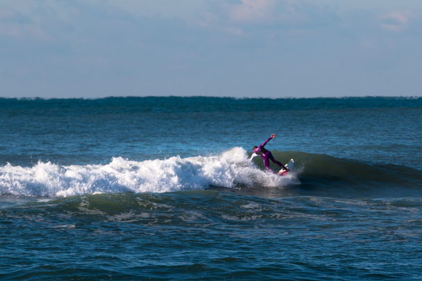 Surfer fioletowy kombinezon jazda na fali - Zdjęcie, obraz