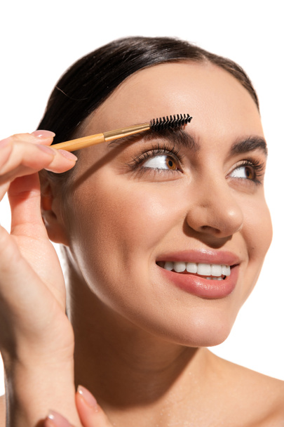 close up of happy young woman styling eyebrows with brush and gel isolated on white  - Φωτογραφία, εικόνα