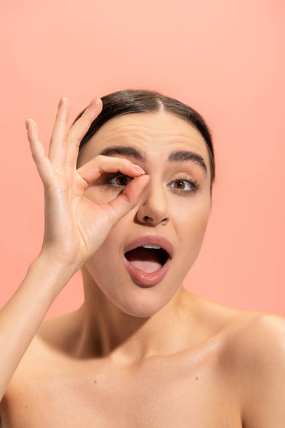 amazed woman with opened mouth showing ok sign isolated on pink  - Photo, image