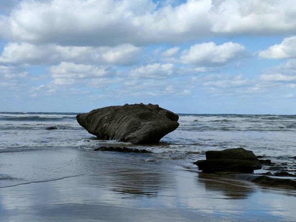stone reefs against the blue sky at low tide on the ocean - Photo, Image