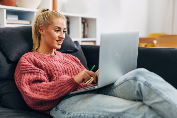 Beautiful blond woman is working on her laptop - Фото, изображение