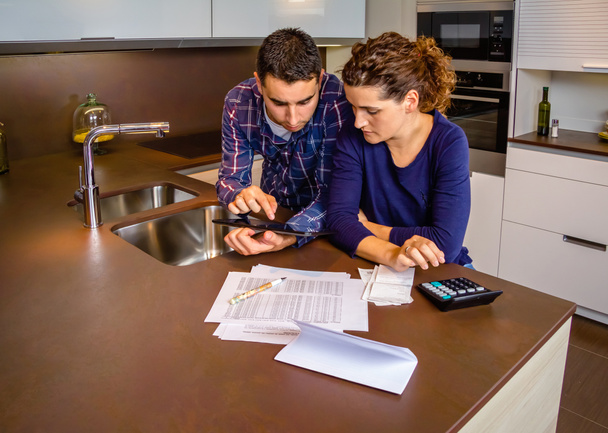 Couple examinant leurs comptes avec une tablette numérique
 - Photo, image