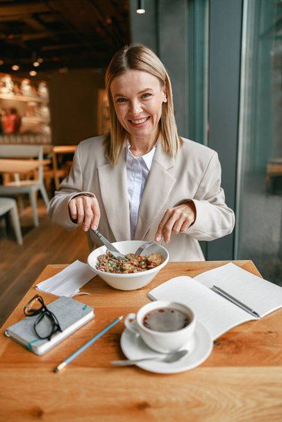 Businesswoman is having a business lunch during working day in cafe. High quality photo - Zdjęcie, obraz