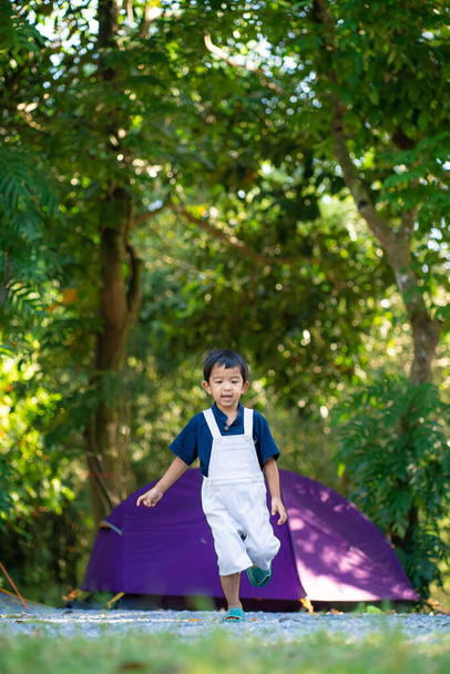 Happy boy in camping tent adventure activity in forest outdoor park - Foto, Imagen