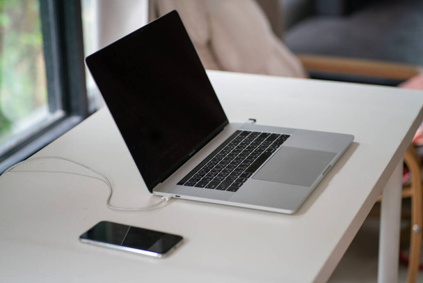 Ordinateur portable sur table blanche sceen noir dans le travail confortable de la maison concept - Photo, image