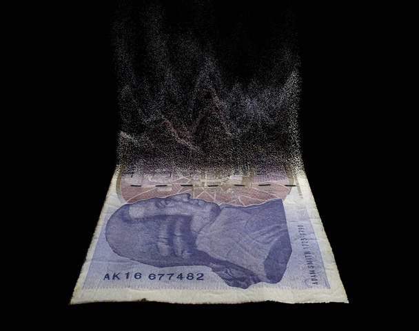 A concept image showing a half dissolved flat paper UK pound bank note on a dark studio background - 3D render - Zdjęcie, obraz