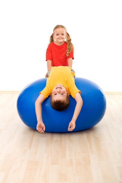 Kids doing exercises on large rubber ball - 写真・画像