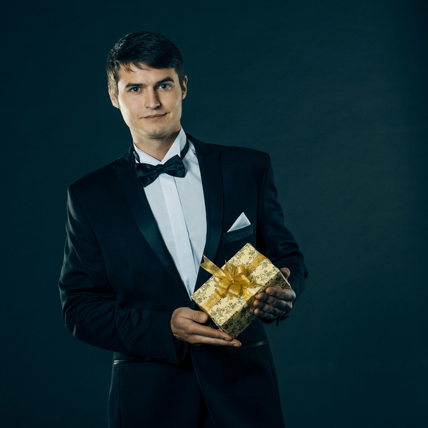 Man in a tuxedo gives a gift - Fotografie, Obrázek