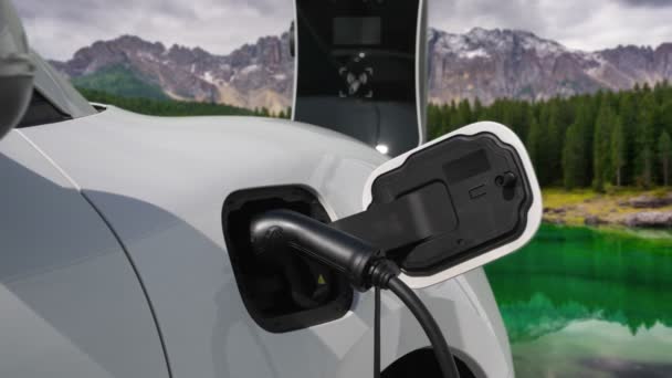 Natural scenic with timelapse of cloud in sky above mountain as background for progressive concept of electric car driven by clean energy for clean environment. EV car recharging at charging station. - Footage, Video