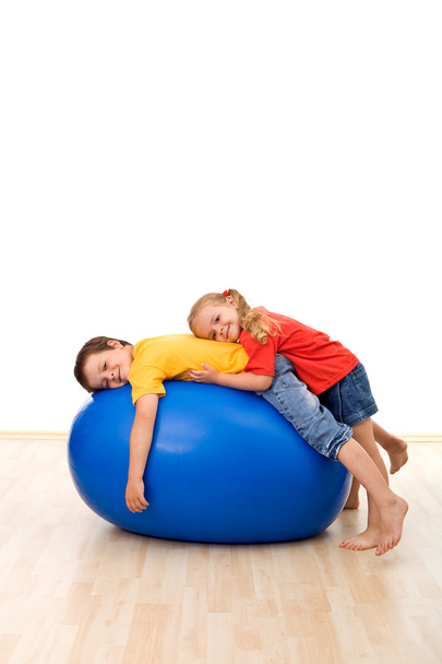 Kids having fun relaxing on a large rubber ball - Fotó, kép