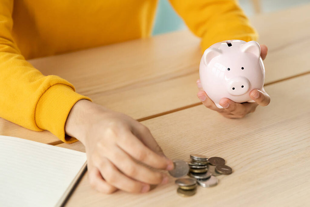 Saving money investment for future. Female woman hands holding pink piggy bank and putting money coin. Saving investment budget business wealth retirement financial money banking concept - Foto, Imagem