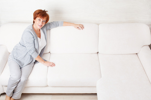 Щаслива зріла жінка на дивані
 - Фото, зображення
