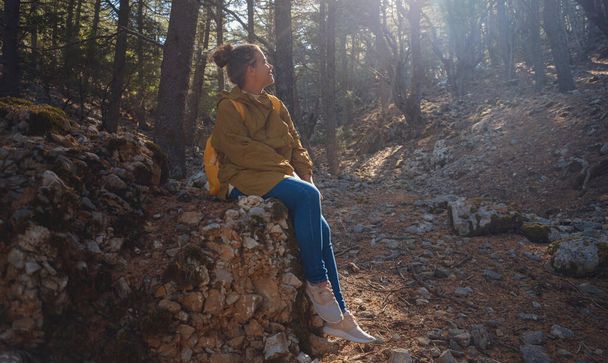 caucasian woman enjoys being in nature, beautiful forest in mountains. embracing fresh air and engaging in outdoor activities. Friluftsliv concept means spending as much time outdoors as possible - Photo, Image