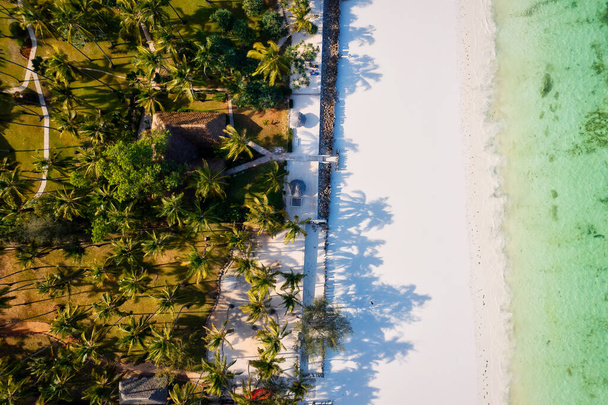 Het uitzicht vanuit de lucht op de kust van de Indische Oceaan van Zanzibar is adembenemend, met palmbomen, wit zand en sprankelend blauw water. Met luxe hotels en een tropisch landschap is het de perfecte bestemming voor een zomervakantie.  - Foto, afbeelding