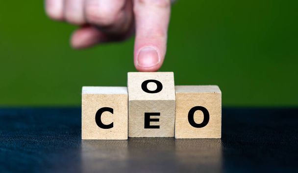 Hand turns cube and changes the abbreviation COO (chief operating officer) to  CEO (chief executive officer). - Fotoğraf, Görsel