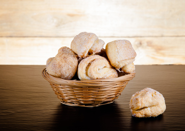Basket of cookie on a black table against old wooden background. - Foto, immagini