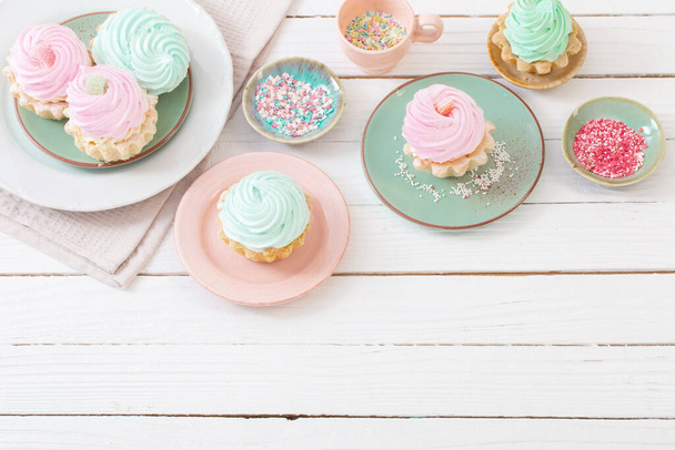 cupcakes on plates on white wooden background - Foto, afbeelding
