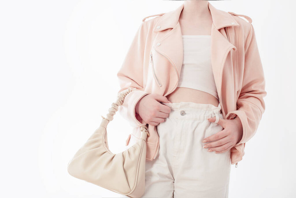young woman in pink jacket with bag on white background - 写真・画像