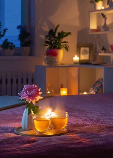 cozy bedroom in  evening with flowers and tea - Φωτογραφία, εικόνα