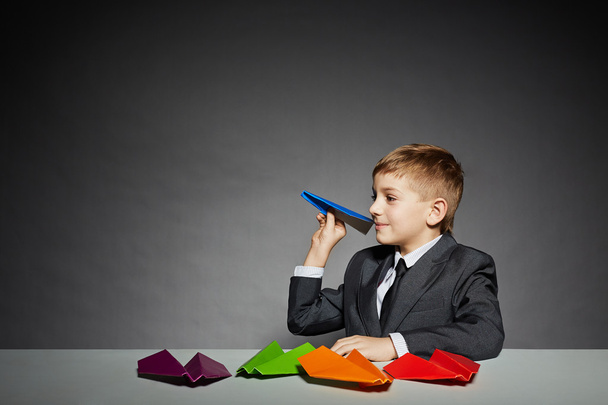 Boy in  suit about to launch color paper plane - Fotoğraf, Görsel