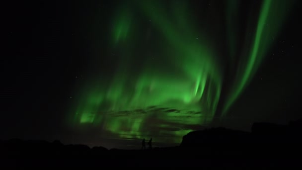 Mensen lopen onder actieve aurora borealis real-time video - Video