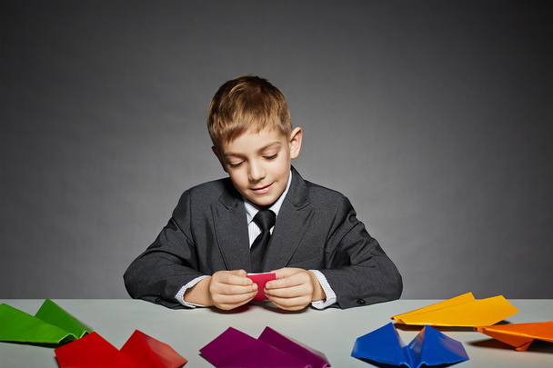 Boy in business suit making color paper planes - Foto, Imagen