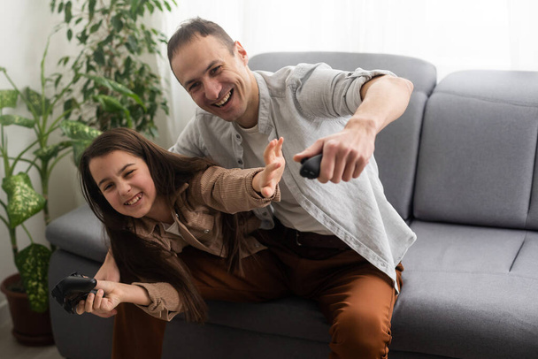 excited father and daughter playing video game at home - Photo, Image